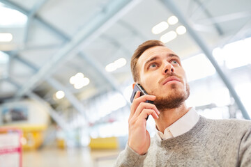 Reisender telefoniert mit Smartphone im Flughafen