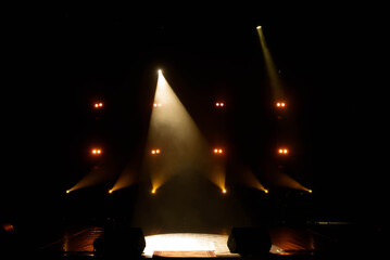 The light of searchlights in smoke on stage of the theatre.