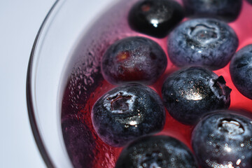 Blueberry jelly in glasses. Pink and blue background from berries. Berry sweet dessert.