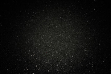 Black texture with micro-relief and glitter. Black glitter texture with illuminated center