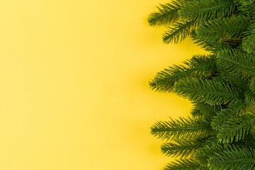 Obraz premium Top view of frame made of fir tree on colorful background with copy space. Merry Christmas concept