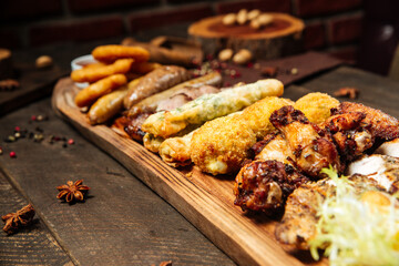 Fried beer snacks on the wooden board with sauces