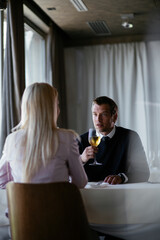 Handsome businessman dressed in the suit drinking wine. Businessman enjoying in the restaurant