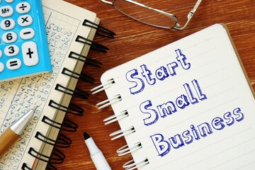 Business concept meaning Start Small Business with sign on the sheet.