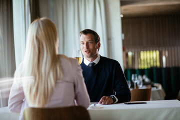 Handsome businessman dressed in the suit drinking wine. Businessman enjoying in the restaurant