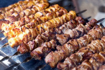 Marinated shashlik preparing on a barbecue grill over charcoal. Shashlik or Shish kebab popular in Eastern Europe. Shashlyk (skewered meat) was originally made of lamb. Roast Beef Kebabs On BBQ Grill.