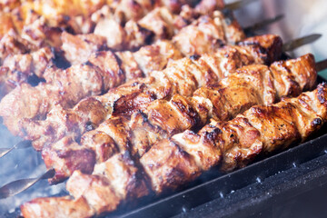 Marinated shashlik preparing on a barbecue grill over charcoal. Shashlik or Shish kebab popular in Eastern Europe. Shashlyk (skewered meat) was originally made of lamb. Roast Beef Kebabs On BBQ Grill.