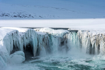 Scenic winter view of Godafoss waterfall in Iceland. Picturesque winter landscape with frozen waterfall in Iceland.