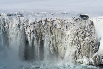 Scenic winter view of Godafoss waterfall in Iceland. Picturesque winter landscape with frozen waterfall in Iceland.