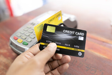 Hand using credit card with NFC technology in a supermarket close up.
