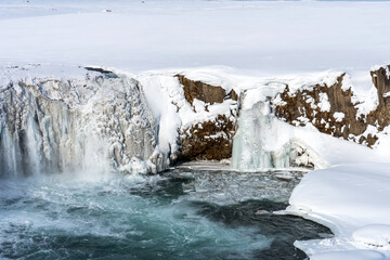 Scenic winter view of Godafoss waterfall in Iceland. Picturesque winter landscape with frozen waterfall in Iceland.