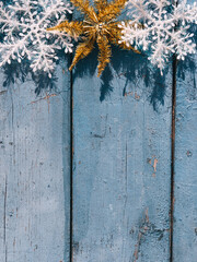 Wooden Christmas background, top view. Place for text on a new year's background. Beautiful blue Christmas vertical background with white snowflakes and Golden shiny star.