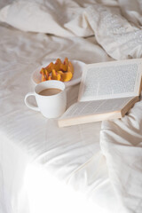 Morning. Cup of coffee, peach and book on the bed, Lifestyle. Mentlhealth. The consept of heathy life.
