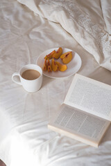 Morning. Cup of coffee, peach and book on the bed, Lifestyle. Mentlhealth. The consept of heathy life.