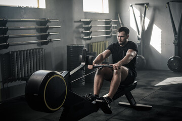 Focused Man Train on Rowing Machine .