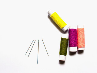 spools of thread and needle on isolated white