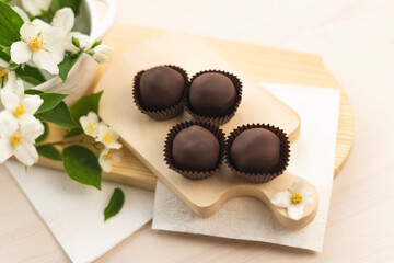 Handmade chocolates on a light wooden background. Chocolate balls raw