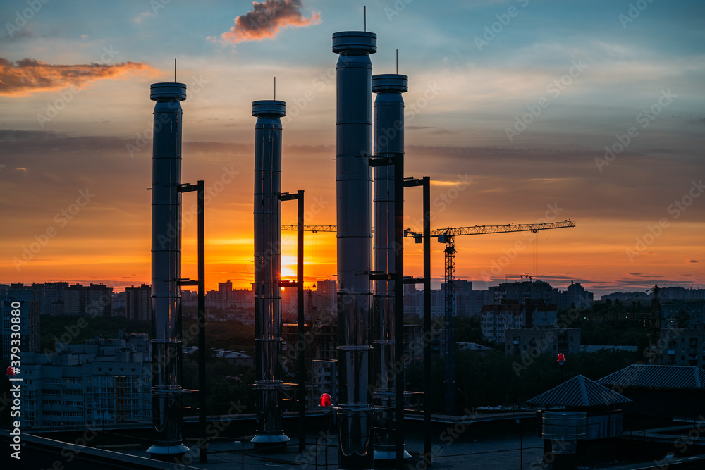 Wall mural Modern rooftop with ventilation pipes on evening sunset