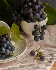 Grapes on a white saucer and a dark background.