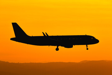 Airplane landing at sunset