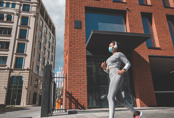 Running girl in a medical mask and headphones