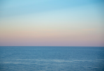 Obraz premium Gentle pastel sunset over the calm surface of the sea.