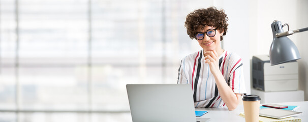 Portrait of business woman looking at camera at workplace in an office