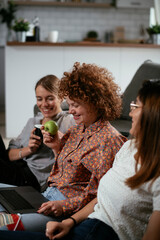 Girlfriends talking and laughing in office. Beautiful women drinking coffee in the office.