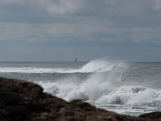 mer agitée avec voilier  prenant la mer