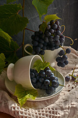 Grapes on a white saucer and a dark background.