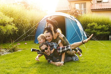Family having fun camping in their house garden