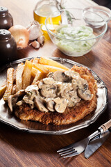 Traditional hunter schnitzel with a mushroom gravy and french fries