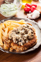 Traditional hunter schnitzel with a mushroom gravy and french fries
