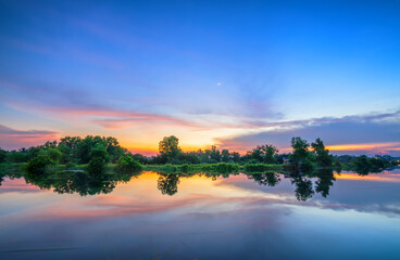 The sunset on the riverbank reflects the peaceful background in the countryside