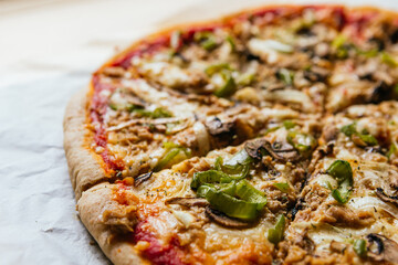 Close-up of a delicious homemade italian pizza with cheese, tomatoes, mushrooms and green pepper