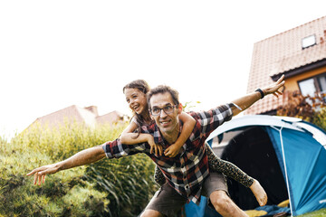 Family having fun camping in their house garden