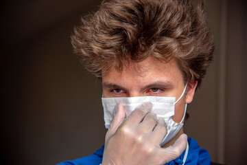 Portrait of a teenage boy in a protective mask on an abstract background.