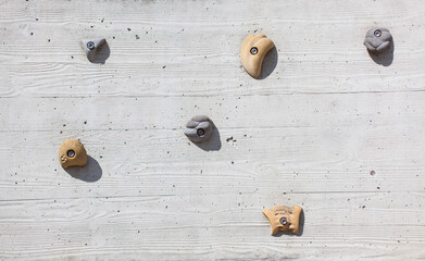 Concrete climbing wall. Climbing holds on wall. Wooden formwork poured with concrete. Wood look. Kletterwand aus Beton. Klettergriffe auf Betonwand. Holzverschalung mit Beton gegossen. Holzoptik.