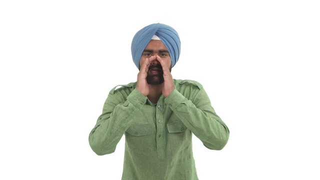 Young beard Indian man makes cupping gesture, calling someone with hands around his mouth. Isolated on white background