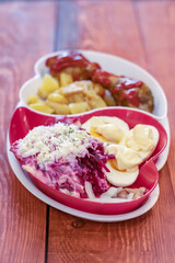 Set of salad herring under a fur coat and fried potatoes and chicken legs.