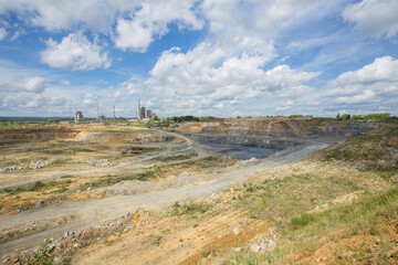 Big open pit limestone quarry mine with working drilling machines, excavators, trucks