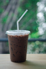 Iced coffee Mocha in disposable plastic cup on wood table