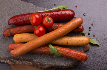 sausages and vegetables on a stone