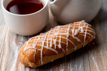 Russian yeast dough bun with white chocolate drops and poppy filling, lose up on a wooden background