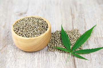 Cannabis seeds, wooden cups and cannabis leaves to extract hemp oil The concept of extracting hemp...