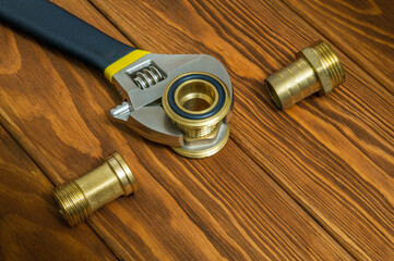 Plumbing brass fittings with adjustable wrench on vintage boards. Idea of working environment of...