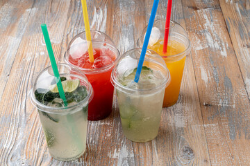 Top view of summer lemonades in plastic cups with straws