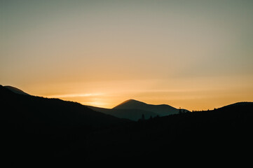 Silhouette of mountains at sunset or sunrise.