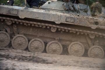 Fototapeta na wymiar Iron caterpillars of the military heavy tank.The caterpillar of a tank driving through the mud close-up. 