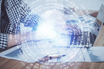 Fingerprint hologram with businessman working on computer on background. Security concept. Double exposure.
